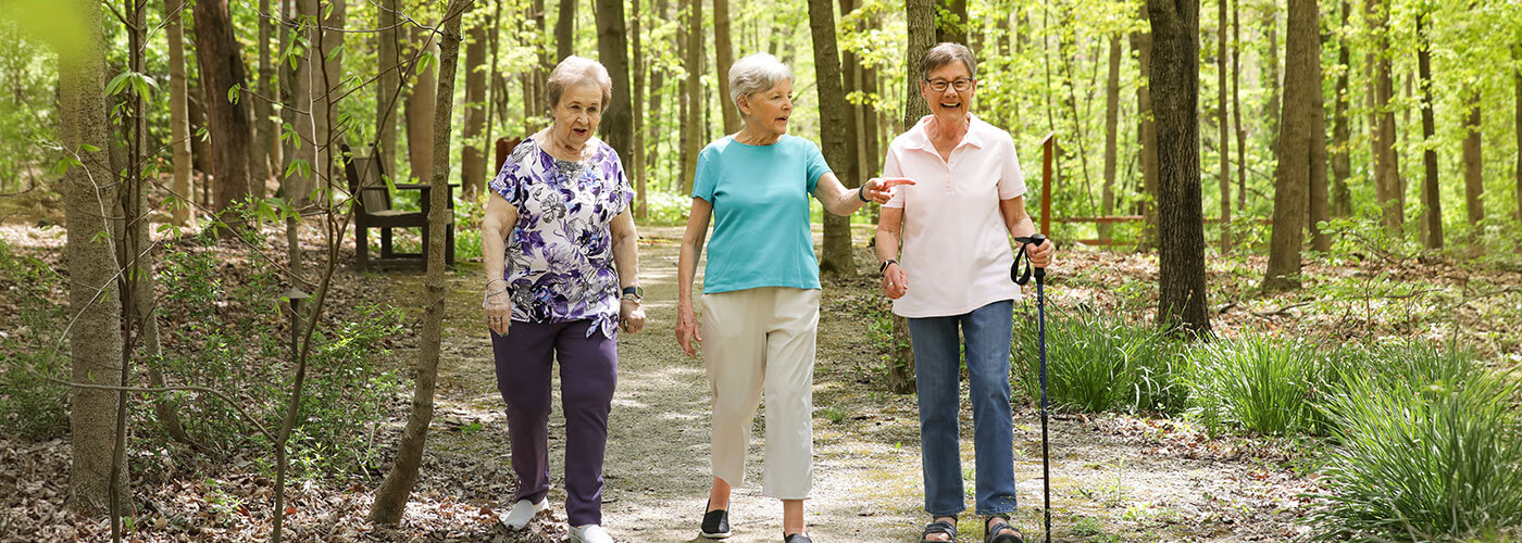 Three senior women walking down one of the Westerwood trails.