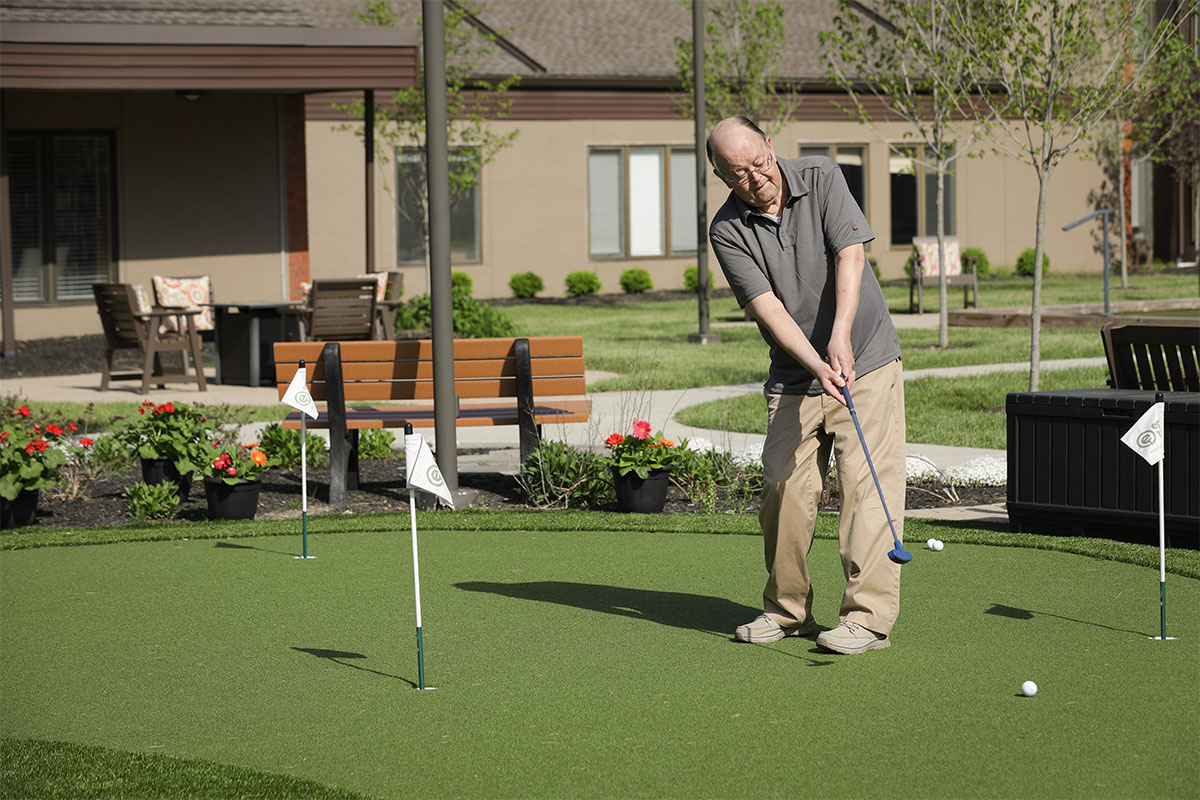 Senior man putting at the Westerwood putting green.