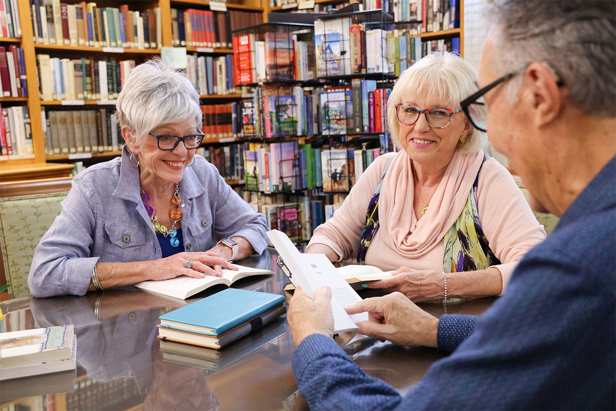Three senior adults enjoying book club at the Westerwood library.