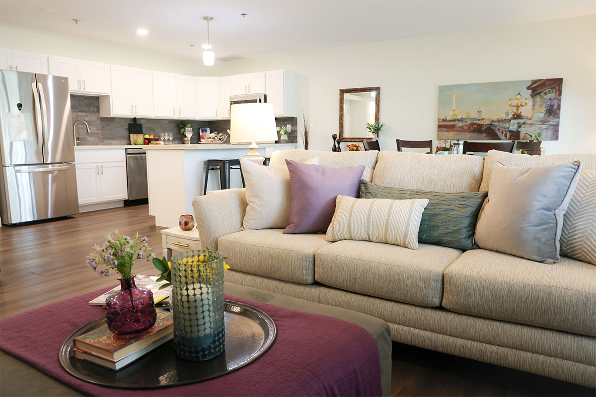 Living room with a view into the kitchen and dining area of a Westerwood apartment.