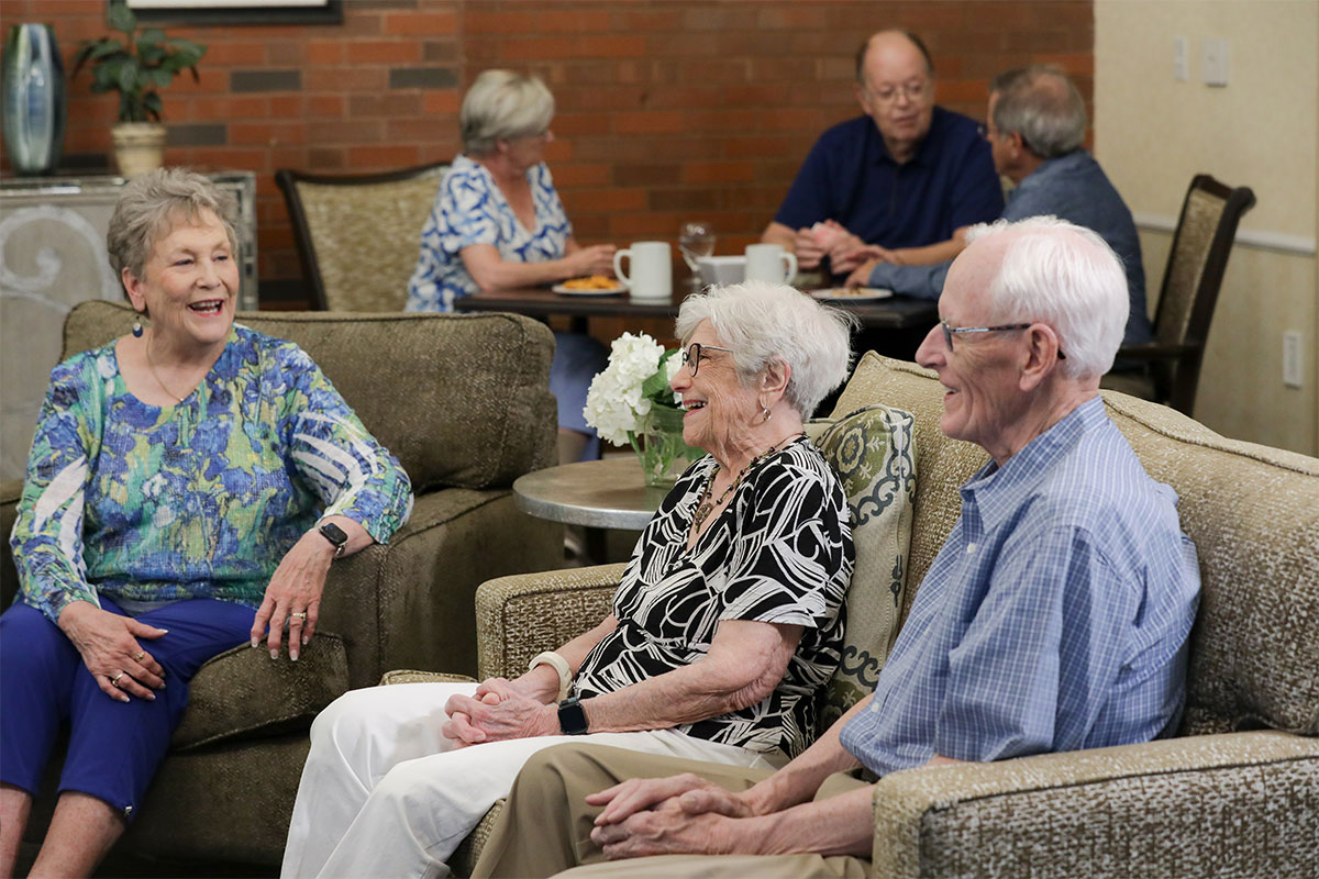 Group of friends smiling and talking in the Friendship Lounge.