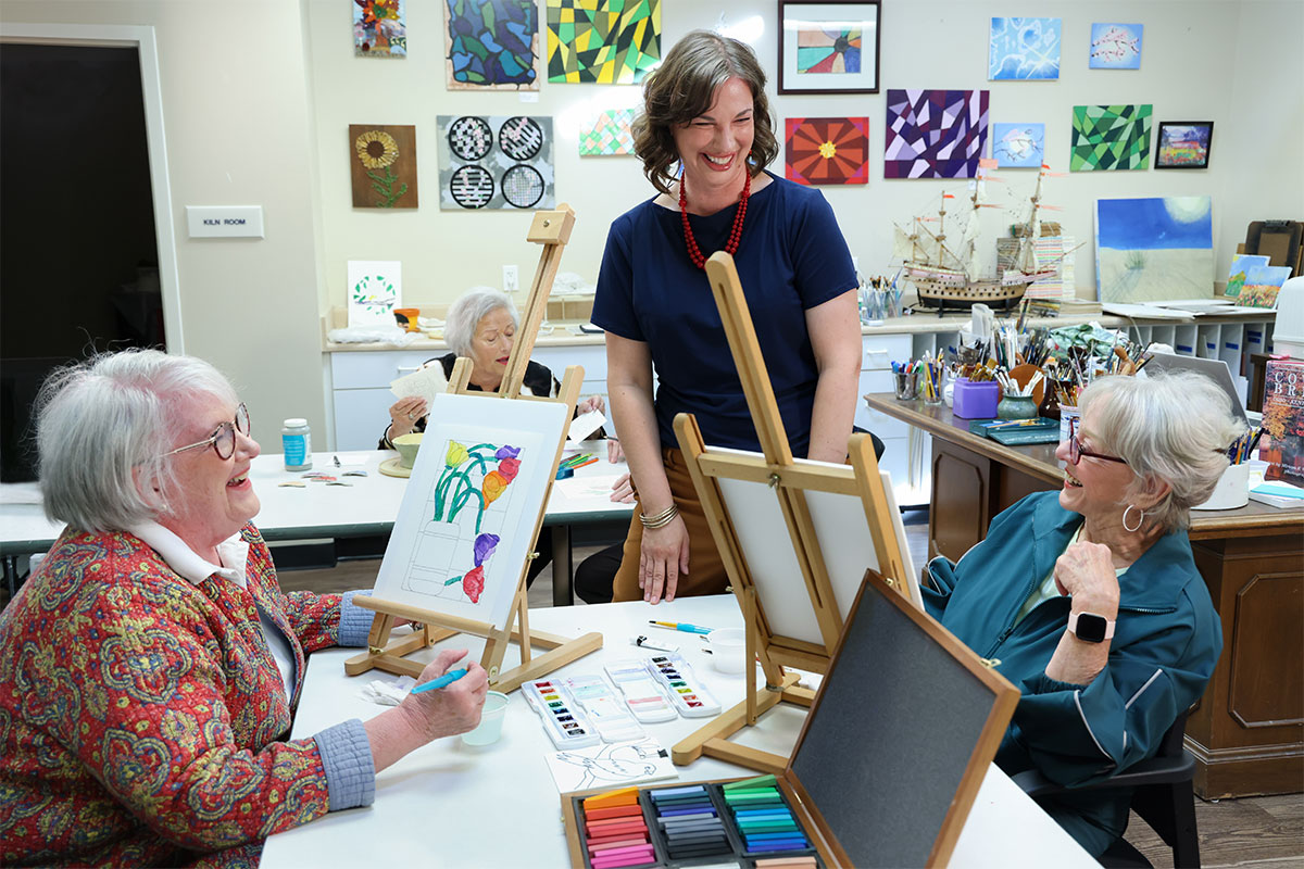 Group of friends enjoying an art class and talking with the art instructor.