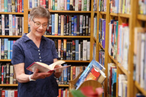 senior woman reading a book in the library