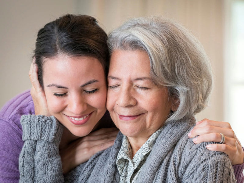 younger woman and senior woman in a loving embrace