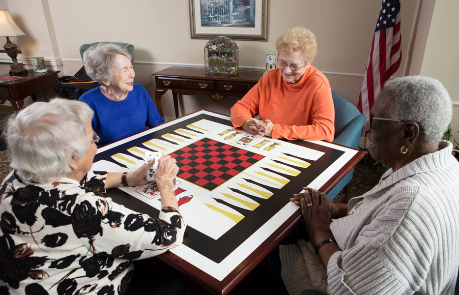group of women at a board game table playing cards