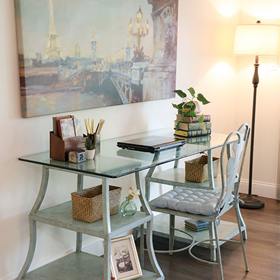 small glass desk with laptop and decor