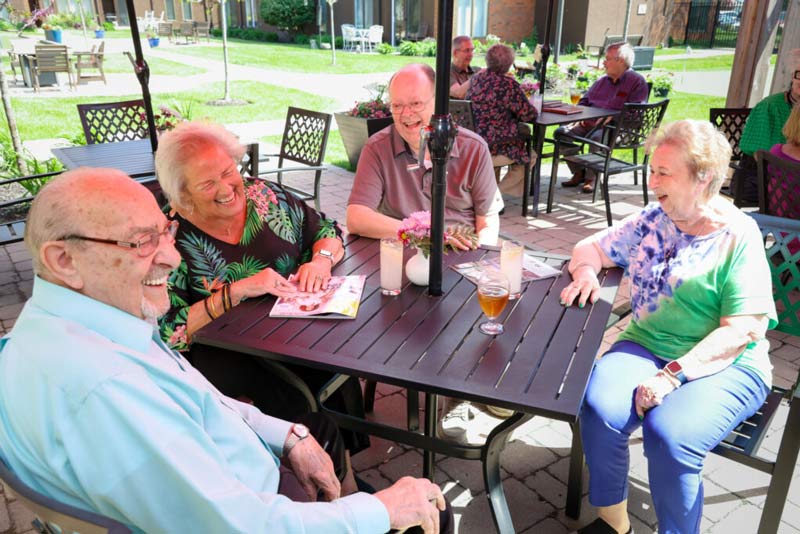 A group of senior citizens enjoying lunch at an outdoor dining space