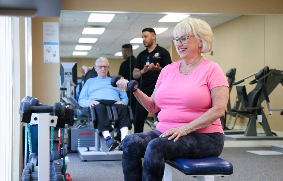 Woman-lifting-weights Senior woman lifting weights in fitness studio