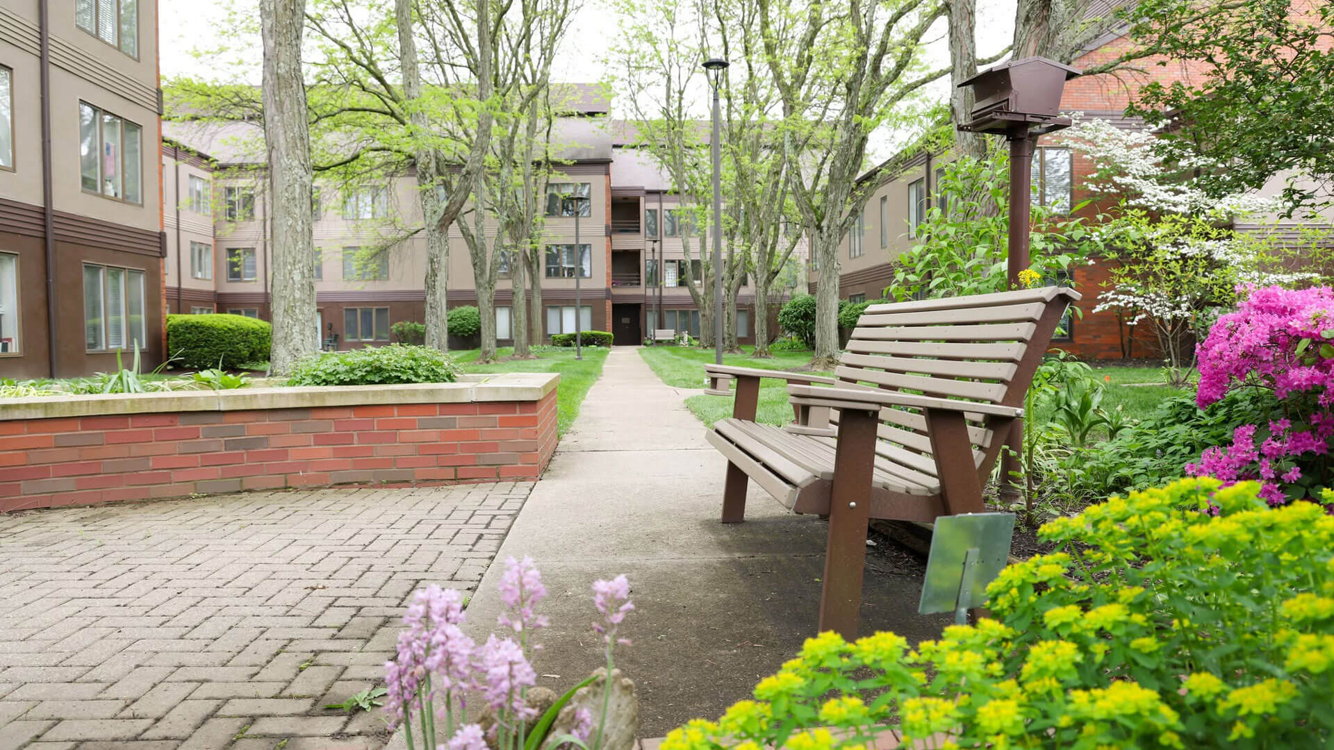 interior-hero bench next to bird house and vibrant flowers on the Westerwood campus